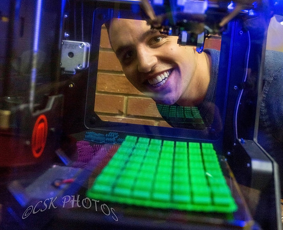 INVENTOR LOOKS AT HIS WORK IN A 3D PRINTER